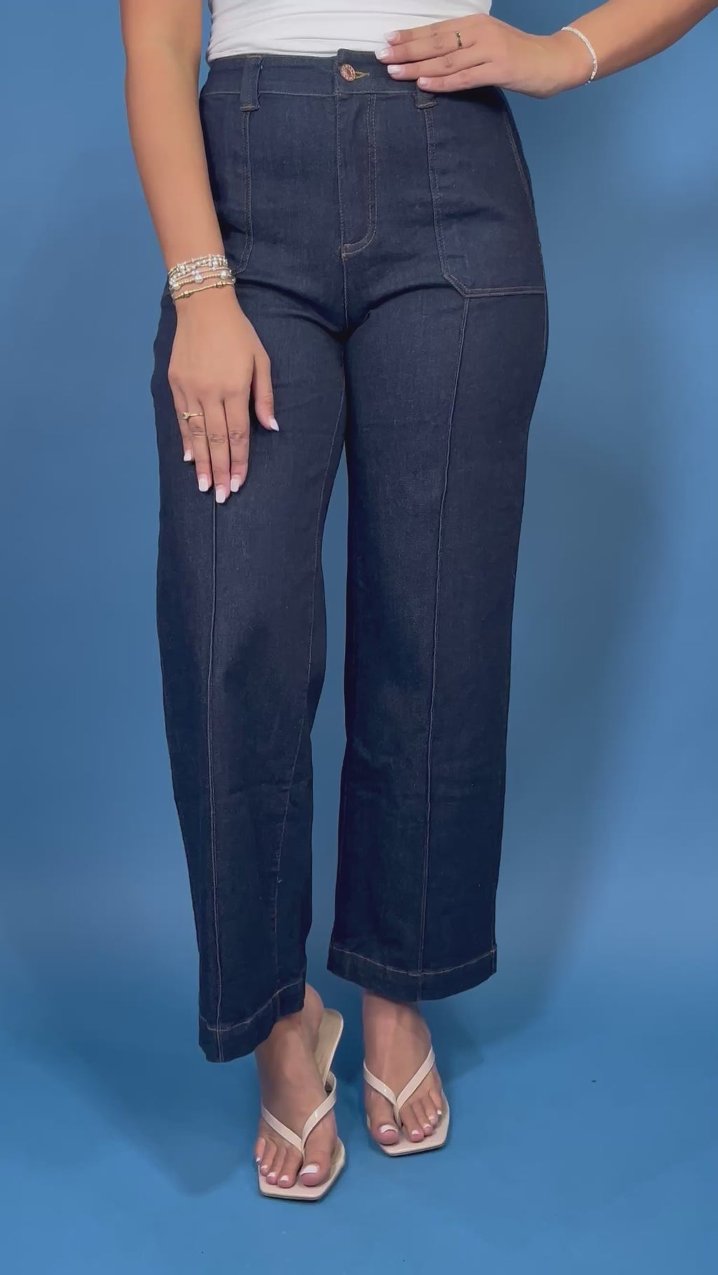 Dark wash high-rise wide leg jeans with front patch pockets, flattering seam details, and a cropped ankle-length silhouette.
