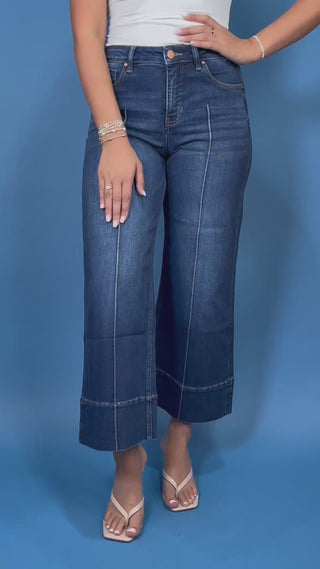 Dark wash high-rise cropped wide leg jeans with statement front seam detailing, subtle fading, and a wide cuffed hem.