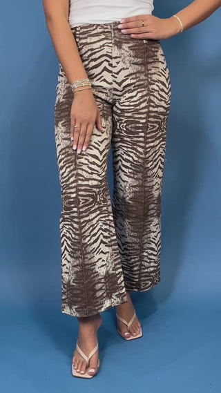 Brown and cream zebra print high-rise pants with a wide-leg silhouette, cropped length, and bold allover animal print.