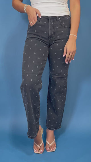 Black high-rise polka dot jeans with subtle gray dots, a flattering slim straight-leg fit, and ankle-length silhouette.