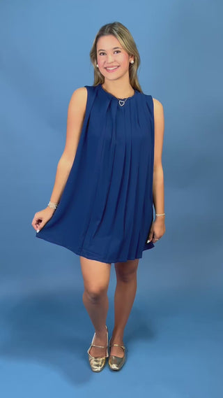 A woman modeling a sleeveless navy blue pleated mini dress