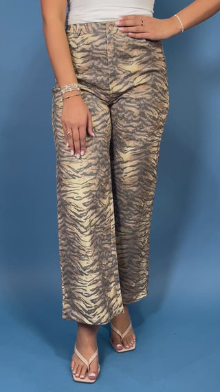 Tan and black tiger print high-rise wide leg jeans with a bold allover animal print and flattering cropped length.