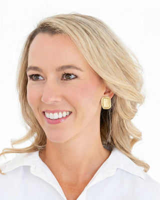 Woman wearing gold earrings with a white background