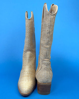 A pair of mid-calf western boots with a woven snakeskin texture in beige and brown, shown from the back against a solid