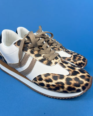 A pair of low-top sneakers featuring a leopard print pattern on the toe and side panels, white leather overlays, white laces,