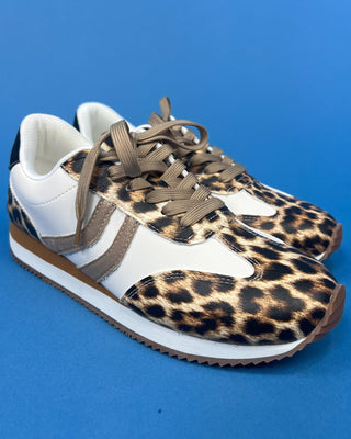 A pair of low-top sneakers featuring a leopard print pattern on the toe and side panels, white leather overlays, and brown la