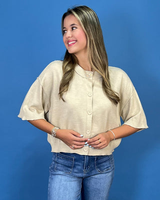 A woman modeling a short-sleeve collared shirt dress with a blue, white, and yellow wavy zebra-like pattern, posed against a