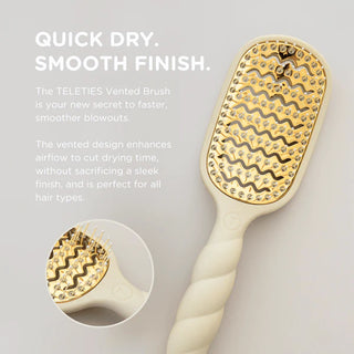White hairbrush with gold bristle head on a light gray background, featuring text about the TELETIES Vented Brush.