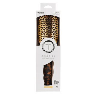 Packaged hairbrush with tortoiseshell pattern on a white background